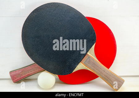 Deux raquettes de tennis de table et d'une balle sur une table en bois Banque D'Images