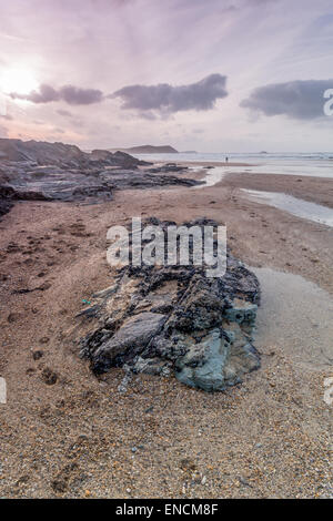 Plage de Polzeath cornwall england uk, comme le soleil se couche entre les roches Banque D'Images