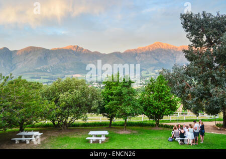 Groupe de jeunes vin dégustation devant le paysage des vignobles de Franschhoek, Afrique du Sud Banque D'Images