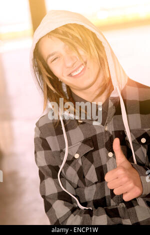 Portrait de vie d'un jeune homme avec des cheveux rasta tons chauds filtre appliqué Banque D'Images