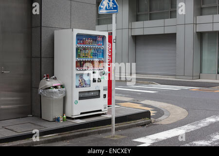 Débordant d'une poubelle à côté d'un distributeur automatique de boissons, Tokyo, Japon. Banque D'Images