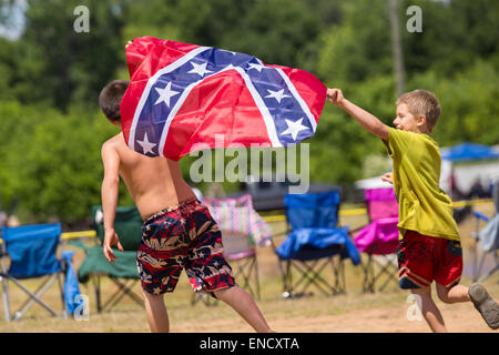 Augusta, Géorgie, USA. 2 mai, 2015. Les jeunes garçons courir autour avec un drapeau des confédérés au cours de la National Championships 2015 Red Neck 2 mai 2015 à Augusta (Géorgie). Des centaines de personnes ont participé à une journée de sport et d'activités de pays. Banque D'Images