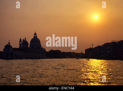 Venise, Province de Venise, Italie. Apr 30, 2015. Le soleil se couche derrière la célèbre 17e siècle dôme baroque de Santa Maria della Salute, une église catholique et basilique, emblématique de la ville de Venise et sa ligne d'horizon, debout sur l'étroit doigt de Punta della Dogana, entre le Grand Canal et le Canal de la Giudecca, à le bassin de St Marc (Bacino di San Marco). Venise est l'un des plus populaires destinations touristiques internationales. © Arnold Drapkin/ZUMA/Alamy Fil Live News Banque D'Images