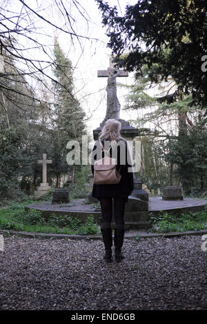 Jeune femme debout dans un cimetière Banque D'Images