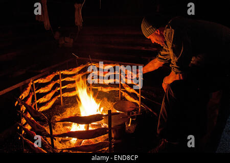 Torréfaction pêcheur Saibling fish sur feu ouvert dans Fischerhütte, Altaussee, Styrie, Autriche Banque D'Images