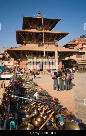 Le Népal, Katmandou, Patan, Durbar Square, Bhimsen Temple Hindou (reconstruite en 1682) avec Lion statue sur une colonne et market stall Banque D'Images