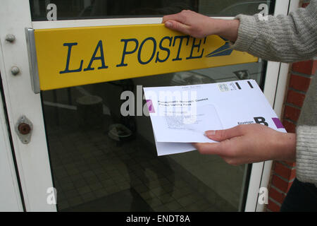 Assurance britannique, Julia White, 31 ans, prend son formulaire de vote par correspondance à un bureau de poste français. Le vote doit arriver avant 10h00 le 7 mai 2015 Banque D'Images