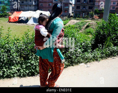 Lalitpur, Prabhat Kumar Verma/Pacific Press. 06Th Mai, 2015. Une femme porter son enfant dans le dos. Lalitpur, est l'une des ville qui a été touchée par le séisme, il y avait un dommage considérable mais la plupart des bâtiments étaient encore intacts. Le Népal 2015 tremblement de terre qui a tué plus de 7 000 personnes et blessé plus de deux fois plus nombreux, le 25 avril, avec un moment de grandeur 7.8. © Prabhat Kumar Verma/Pacific Press/Alamy Live News Banque D'Images