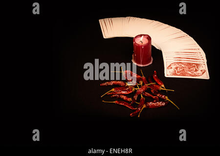 Dans l'illustré d'un paquet de cartes éventail ouvert , une bougie rouge et le poivron rouge sèche. Banque D'Images