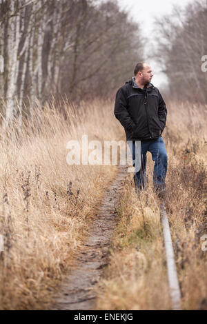 Homme d'âge moyen est de marcher le long des voies de chemin de fer abandonnée / hâte à la façon de vivre Banque D'Images