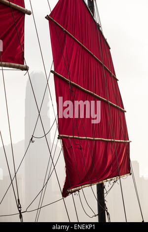 Toile rouge traditionnel de Hong Kong, le gréement et voiles mât d'un bateau ancien et moderne à l'horizon l'arrière-plan Banque D'Images