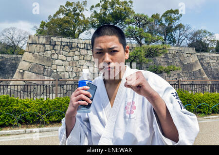 Adolescent japonais en position de combat de karaté. Il est debout dans la rue, vêtu de kimono et posing Banque D'Images