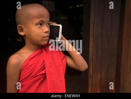 Moine Novice appelant sur un téléphone mobile dans le Nat Taung Kyaung Monastère, Bagan, Myanmar Banque D'Images