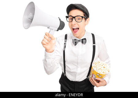 Jeune mec en atelier artistique tenant une boîte de pop-corn et intervenant sur un mégaphone isolé sur fond blanc Banque D'Images