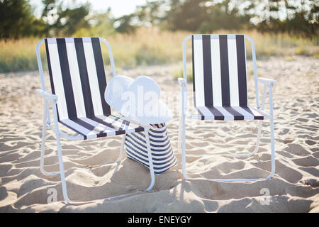 Deux salons de plage avec sac de plage et chapeau blanc Banque D'Images