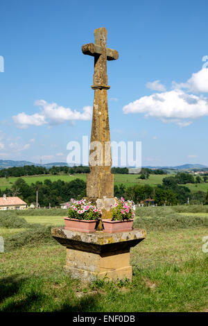 Croix de Pierre à Saint Medard en Forez en Loire du centre de la France avec des tas dans jardin Banque D'Images