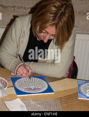 Un travailleur décore une tuile au Musée de la céramique à Avanos, Cappadoce, Turquie. Banque D'Images