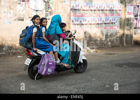 Une mère qui ramène ses enfants à la maison à l'école sur un scooter à fort Cochin à Kochi, Kerala, Inde Banque D'Images