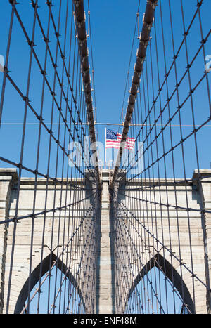 New York, État de New York, États-Unis d'Amérique. Pont de Brooklyn avec le drapeau américain volant au-dessus les câbles et distinct Banque D'Images