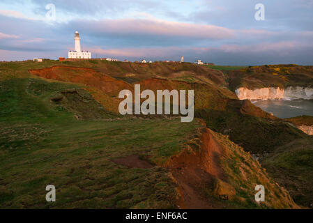 La côte sauvage avec des falaises de craie et le phare moderne comme l'aube sur la mer du Nord à Flamborough Head. Banque D'Images