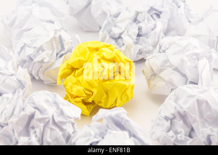 Feuille de papier jaune froissé entre les balles de papier blanc Banque D'Images