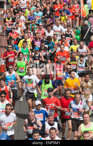 Champ principal, les coureurs prenant part aux organismes de bienfaisance et d'amusement. Les coureurs de marathon en route au point 15.5 miles dans les Docklands de Londres. Banque D'Images