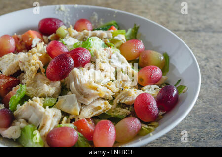 Mélanger avec la salade de poulet et les raisins sur le plat blanc Banque D'Images