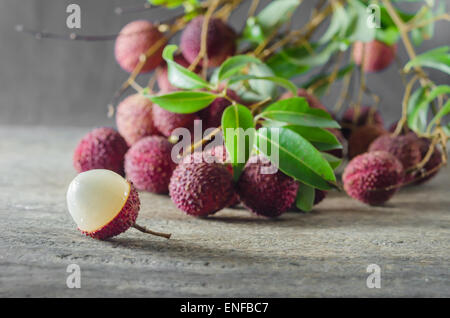 Le litchi avec des feuilles sur une table en bois Banque D'Images