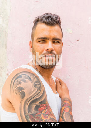 A 20-29 ans hommes hispaniques cubaine montre son bras tatoué dans La Habana Vieja. Banque D'Images