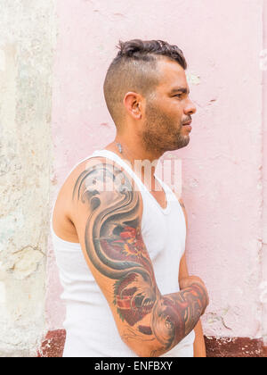 A 20-29 ans hommes hispaniques cubaine montre son bras tatoué dans La Habana Vieja. Banque D'Images