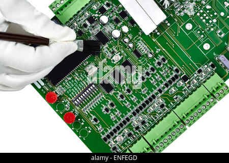 Carte à circuits imprimés, main dans white glove holding brosses de nettoyage le conseil isolated on white Banque D'Images