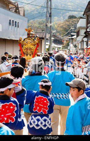 Le festival annuel de printemps de Tada Genji au Japon. Regardez le long de la procession alors qu'ils marchent en portant un sanctuaire portatif mikoshi le long d'une rue étroite. Banque D'Images