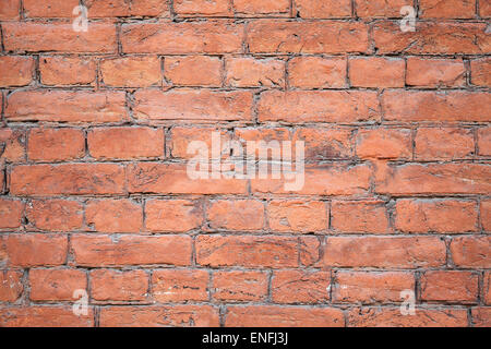 La texture de fond d'un vieux mur de briques peint rouge Banque D'Images