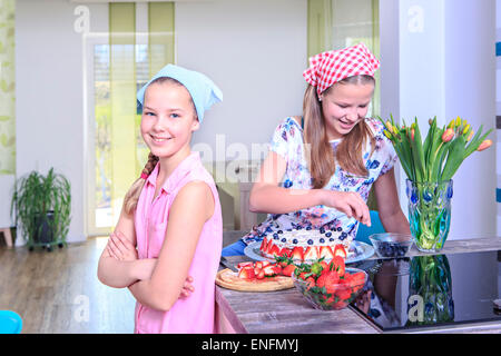 Les jeunes filles la confection d'un gâteau à la maison avec des fruits frais Banque D'Images