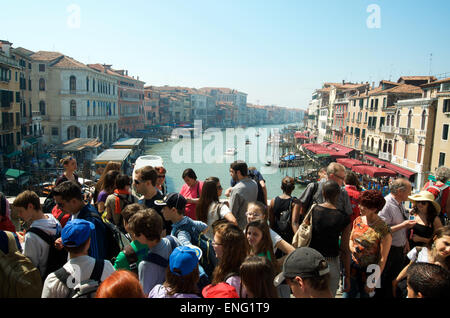 Venise, Italie - 24 avril 2013 : des foules de touristes passent le long du pont du Rialto à l'encontre d'une vue sur le Grand Canal. Banque D'Images