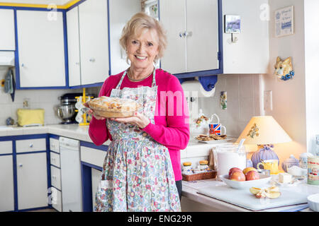 Older Caucasian woman baking pie dans la cuisine Banque D'Images