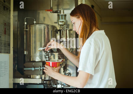 Caucasian woman pouring dans un bol d'eau chaude Banque D'Images