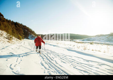 Caucasian woman ski de fond au champ neigeux Banque D'Images