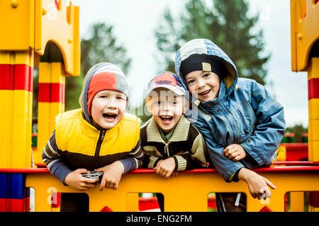 Caucasian boys smiling at aire de jeux Banque D'Images