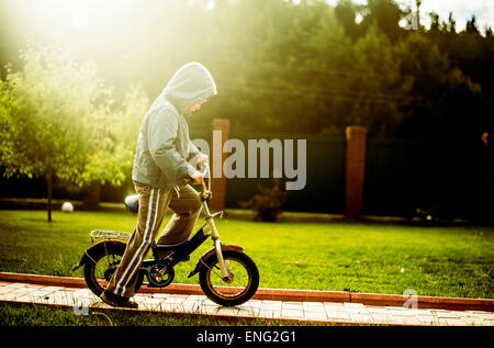 Caucasian boy riding bicycle in backyard Banque D'Images