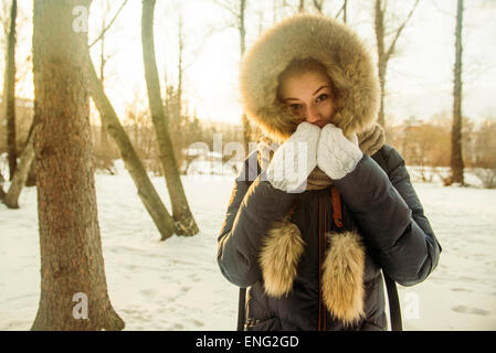 Caucasian woman wearing fur hood et coat in snowy field Banque D'Images