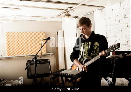 Young man playing electric guitar dans rock band Banque D'Images