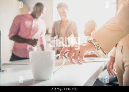 Businesswoman drinking cup of coffee in office Banque D'Images