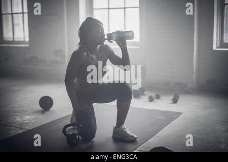 Black woman drinking water bottle in the gym Banque D'Images