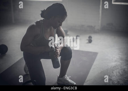 Black woman drinking water bottle in the gym Banque D'Images