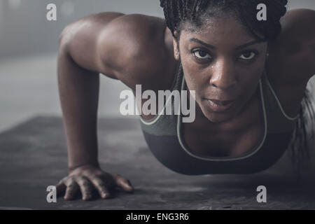 Black woman doing push-ups en salle de sport Banque D'Images