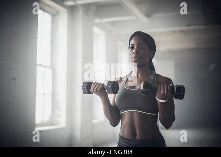 Black woman lifting weights in the gym Banque D'Images