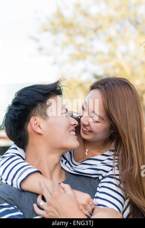 Smiling Korean couple hugging outdoors Banque D'Images