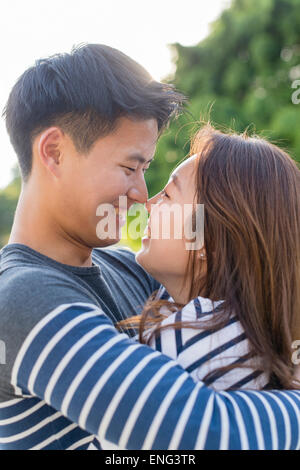 Smiling Korean couple hugging in park Banque D'Images