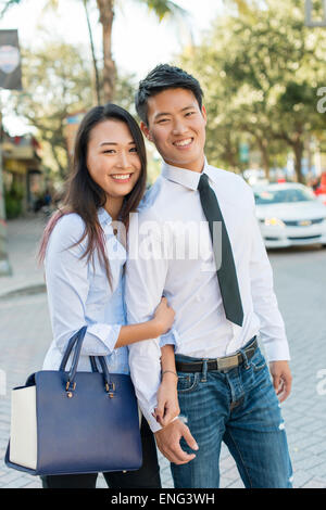 Smiling Korean couple standing in street Banque D'Images